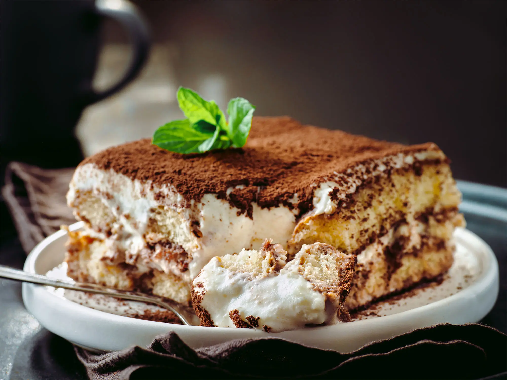 GR Stories | A glass dish of tiramisù dusted with cocoa, served in a small student kitchen
